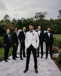 a group of men standing next to each other in tuxedo's and bow ties