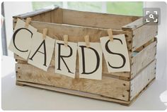 a wooden crate with clothes hanging from it's sides and the words cards on them