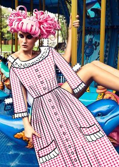 a woman in a pink dress is sitting on a carousel