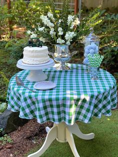 a table topped with a cake next to a vase filled with flowers and greenery