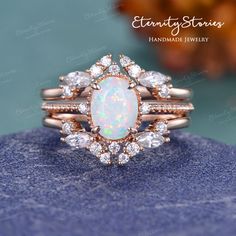 an opal and diamond ring set on top of a blue stone surface with the words,