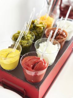 a tray filled with different types of condiments and dips on top of each other