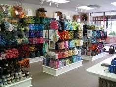 there are many different items on display in the store, including yarns and crochet hooks