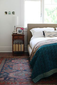 a bed sitting next to a window in a bedroom