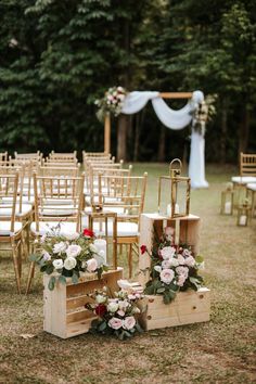 an outdoor ceremony setup with wooden chairs and floral arrangements