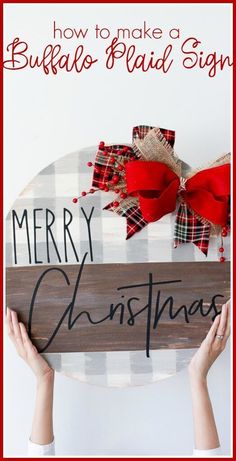 two hands holding up a wooden sign with the words merry christmas written on it and red bows