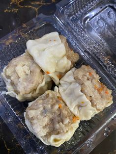 some dumplings are sitting in a plastic container