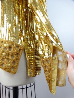 "This beautiful vintage piece is heavily embellished with gold sequins and beading. This piece is very well made and in perfect condition.. absolutely amazing!! Bust - 40\" Shoulders - 18\" Sleeves - 26\" Top Hem to Bottom Hem - 27\" Tag Size - Medium All of my items come from a smoke-free and pet-free home. If you have any questions, please don't hesitate to ask!" Gold Sequin Fabric For Evening, Gold Embellished Sequin Fabric For Evening, Gold Embellished Sequin Fabric For Festive Occasions, Festive Gold Embellished Sequin Fabric, 80s Couture, 90s Couture, Sequin Embellished Top, Golden Dress, Beaded Blouse