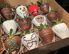 a box filled with chocolate covered strawberries decorated like snowmen and christmas decorations on top of each other