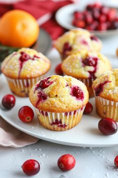 cranberry muffins on a white plate with oranges and cherries