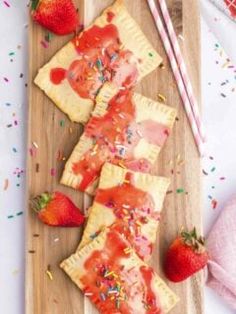 strawberry shortcakes with sprinkles and strawberries on a cutting board