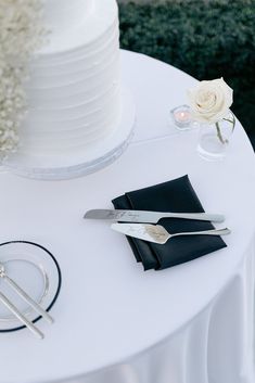 a white table topped with a cake next to a knife and napkin holder on top of it