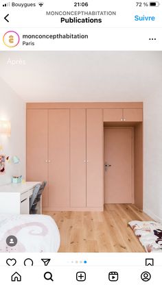 a bedroom with wooden floors and pink cabinets in the wall, along with a bed