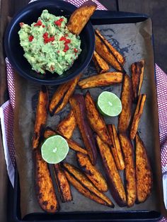 the meal is ready to be eaten on the tray with lime wedges and guacamole