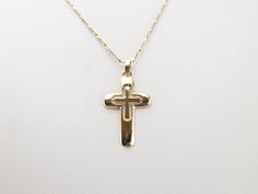 This cross pendant is simple and sleek, crafted of 14 karat yellow gold. Perfectly polished, this piece is a great size for wearing everyday, and is a true classic. This pendant does not come with the chain shown. Please feel free to contact us, we will help you find the perfect chain for your style and budget! Metal: 14K Yellow Gold Measurements: 19 x 35 mm, with bail Marks: "NMI3 14K" Stamped Classic Yellow Gold Cross Necklace, Classic 14k Gold Cross Pendant Necklace, Classic 14k Gold Cross Necklace, 14k White Gold Cross Pendant Necklace, 14k White Gold Cross Necklace, Yellow Gold Polished Cross Necklace Pendant, Cameo Ring, Diamond Cross, Ruby Jewelry