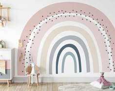 a child's room with a rainbow wall mural