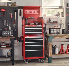 a red toolbox sitting on top of a workbench in a room filled with tools