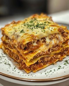 a stack of lasagna sitting on top of a white plate covered in cheese