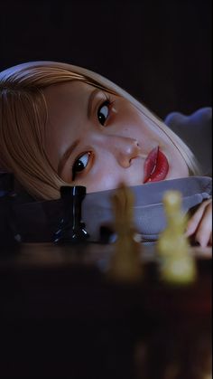 a doll laying on top of a table next to a chess board