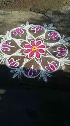 a flower design is painted on the ground with white and pink flowers in the center