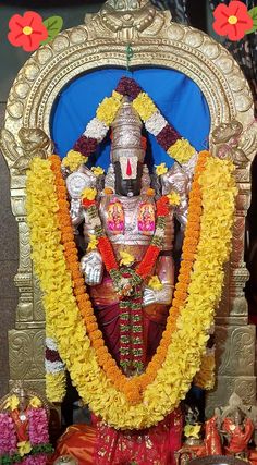 the statue is decorated with flowers and garlands