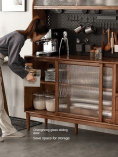 a woman standing in front of a wooden cabinet