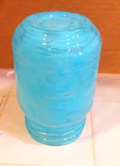 a blue vase sitting on top of a tiled floor