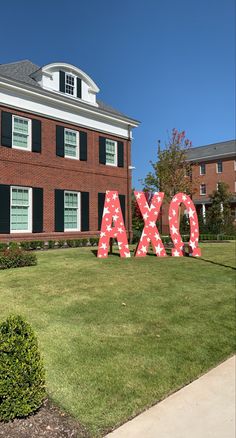 the letters are made out of red and white polka dot paper in front of a large brick building