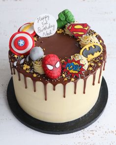 a birthday cake with chocolate icing and decorations on it's top is decorated like the avengers symbol