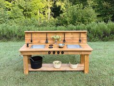 an old fashioned wooden stove sitting in the middle of a field with pots and pans on it