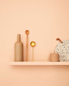 a shelf with vases and other decorative items on it, along with a candle holder