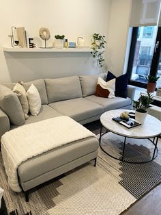 a living room filled with furniture and a large window in the back drop off wall