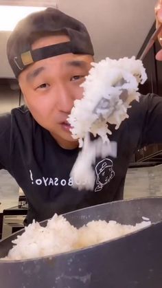 a young boy in a black shirt is eating rice