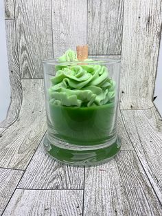 a glass bowl filled with green liquid on top of a wooden table