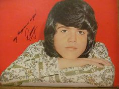 an autographed photo of the singer, micky jones on a red background