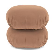 two pillows sitting on top of each other in front of a white background and one is brown