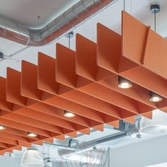 an orange ceiling with some lights hanging from it's sides and two lamps on the other side