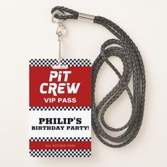 a black and white striped lanyard with a red tag that says pit crew via pass