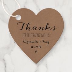 a brown heart shaped tag with the words thanks for celebrating with us on it's side