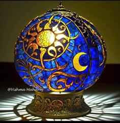 a blue and yellow glass ball sitting on top of a table next to a light