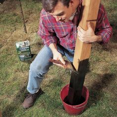 a man kneeling down next to a bucket with something in it on top of grass