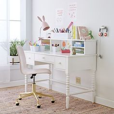 a white desk with a chair and some books on it in a room next to a window