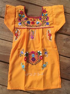 -Beautiful hand embroidered dress -Made of soft comfortable cotton and poplin -Each dress is hand embroidered with colorful floral embroidery -Authentic and Traditional -You will love your unique one of a kind piece -Every dress is individually handcrafted **It may have slight imperfections **Color may vary on stitching as each dress is unique -Perfect gift idea or first year Mexican fiesta **HAND WASH ONLY** Hand wash in cold water, air drying and warm iron if needed Follow us on Instagram @ ma Cotton Dresses With Embroidered Border For Festivals, Orange Cotton Dress For Festivals, Multicolor Cotton Dress With Embroidered Neckline, Embroidered Dress For Fiesta And Festivals, Multicolor Embroidered Cotton Dress For Festivals, Multicolor Cotton Embroidered Dress For Festivals, Short Sleeve Cotton Dresses With Embroidered Border, Cotton Short Sleeve Dress With Embroidered Border, Traditional Yellow Embroidered Cotton Dress