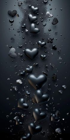 black hearts floating in the air with water droplets on them and some rocks scattered around