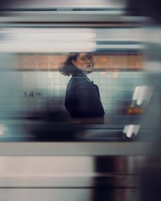 a blurry photo of a woman standing in front of a train