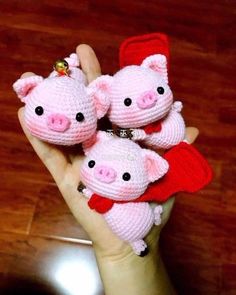 three little pigs are sitting in the palm of someone's hand, wearing red mittens