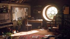 a room with a large round window and lots of clutter on the floor in front of it