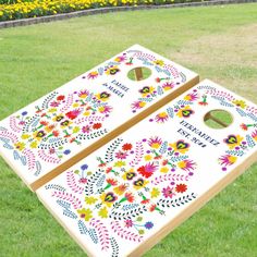 two cornhole boards decorated with colorful flowers