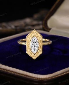 a gold ring with a diamond in it on a blue velvet box and some other jewelry