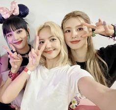 three girls posing for the camera with their hands in the shape of mickey mouse ears